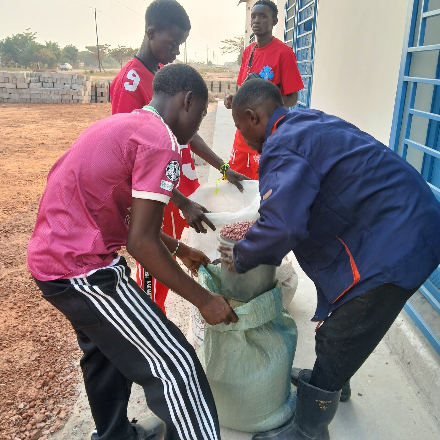 EMVL staff member receiving Mbereshi beans delivered by youth farmers at the Luwingu outlet